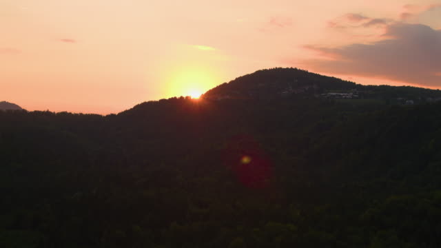 Antenne:-Fliegen-über-dichten-Wald-von-den-atemberaubenden-Sonnenuntergang-orange-beleuchtet.