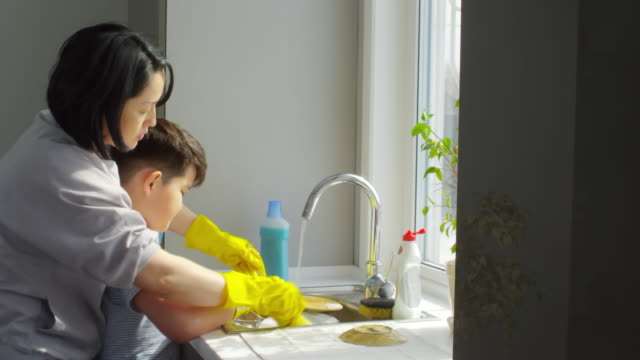 Sohn-Mutter-Lehre-wie-Geschirr-spülen