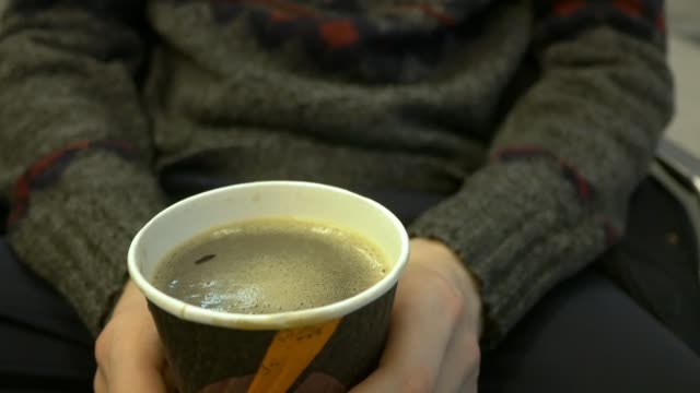 Nahaufnahme,-Person,-Hände-halten-Tasse-und-trinken-Kaffee-am-Flughafen-des-Flugs