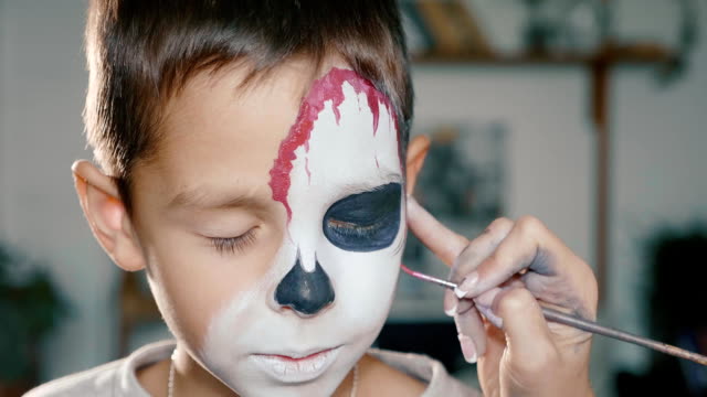 Make-up-artist-conforma-al-niño-hacen-de-halloween.-Arte-de-cara-de-Halloween-infantil.