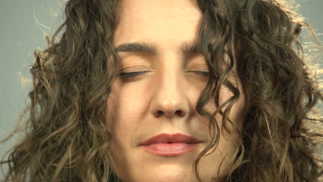 Close-up-of-woman-meditating-with-closed-eyes,-awaken-opens-eyes-staring-camera
