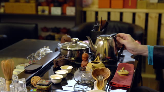 Tee-Zeremonie.-Teekocher-gießt-kochendes-Wasser-in-die-Teekanne