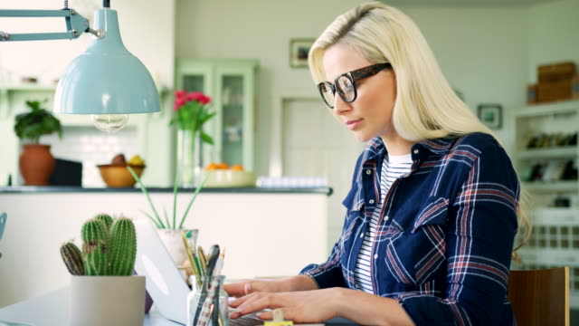 Attraktive-blonde-Geschäftsfrau-Tippen-auf-Laptop-zu-Hause-Büro