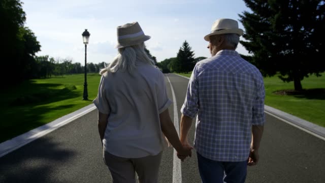 Stylish-senior-couple-walking-holding-hands