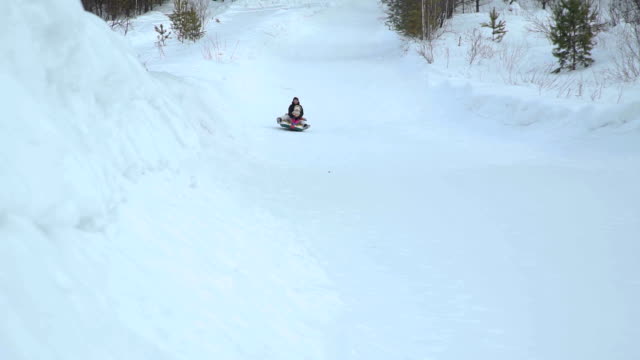 Woman-and-Girl-Riding-Fast-on-a-Sledding-Tubing