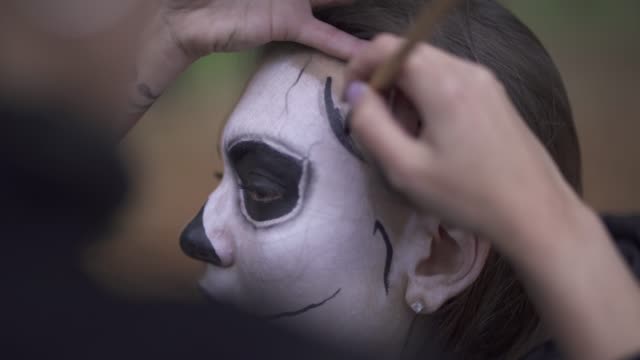 Make-up-Künstler-wendet-Make-up-auf-Mädchen-Gesicht.-Halloween-Urlaub.