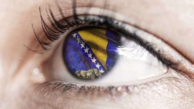 mujer-ojo-verde-en-primer-plano-con-la-bandera-de-Bosnia-y-Herzegovina-en-el-iris-con-el-movimiento-del-viento.-concepto-de-vídeo