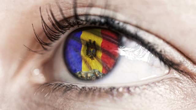 woman-green-eye-in-close-up-with-the-flag-of-Moldova-in-iris-with-wind-motion.-video-concept