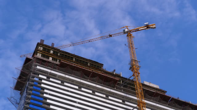 Crane-on-a-Construction-Site-against-the-Blue-Sky-is-Building-New-Skyscraper.-Construcción-de-edificios