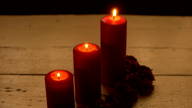 Drei-rote-Kerzen-Licht-mit-Rose-am-weißen-Tisch
