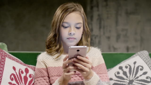 Teen-Girl-Chat-mit-Freund-per-Smartphone-zu-Hause