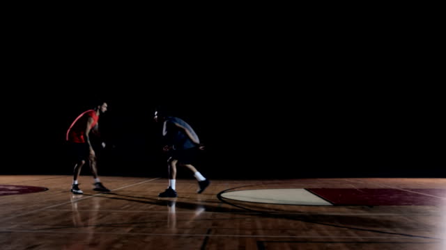 Ein-Basketball-Spieler-macht-einen-Zug-auf-Verteidiger-und-tunkt-den-Ball.