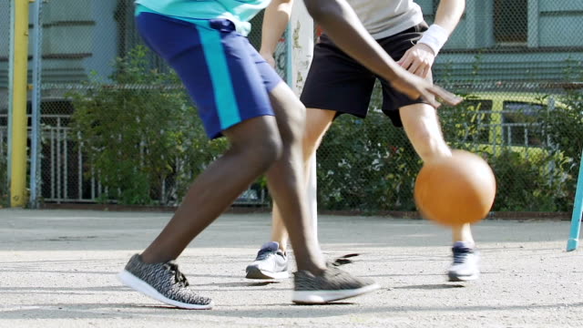 Black-and-white-men-playing-basketball-outside-summer,-dribbling,-competition