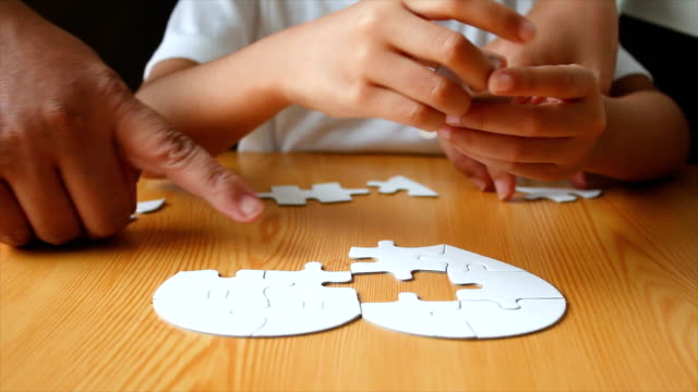 Asiatische-Mädchen-und-Familie-spielen-Puzzle-mit-Mutter-wählen-Sie-Fokus-auf-Seite-flacher-Schärfentiefe