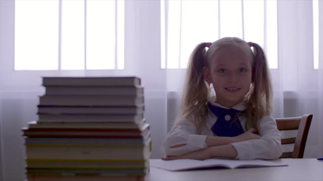 Portrait-school-girl-girl-having-fun-and-dancing-at-table-with-textbooks-stack