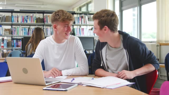 Zwei-männliche-College-Studenten,-die-Arbeiten-am-Laptop-zusammen-In-Bibliothek