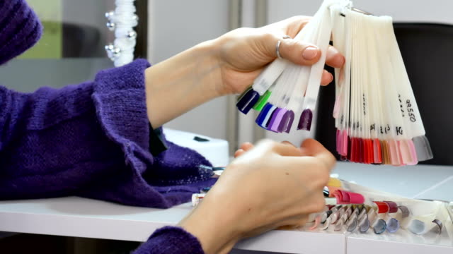Woman-Hands-with-Natural-Manicure-and-Short-Nails-Choosing-Ultraviolet-Nail-Sample-from-Palette.
