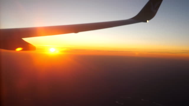 Blick-vom-Flugzeugfenster-zu-schönen-Sonnenaufgang-oder-Sonnenuntergang.-Flügel-des-Flugzeugs-und-Wolke-Himmel.-Konzept-der-Reisen-oder-Tourismus.-Nahaufnahme-Seitenansicht