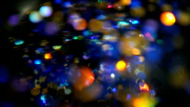 Defocused-shimmering-multicolored-glitter-confetti,-black-background.-Holiday-abstract-festive-bokeh-light-spots.