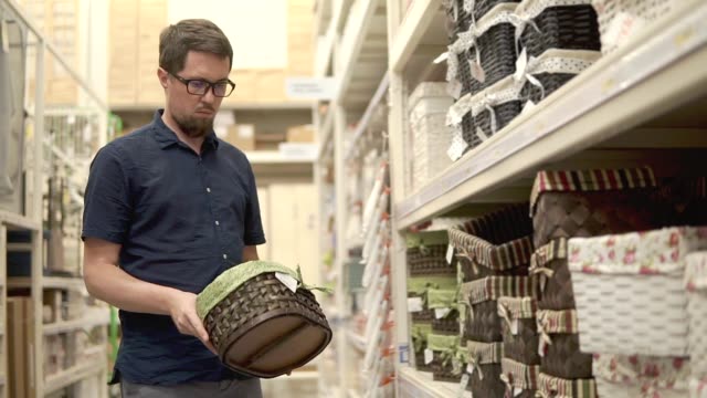 Hombre-es-tomando-diferentes-cestas-de-rejillas-en-una-tienda,-elegir