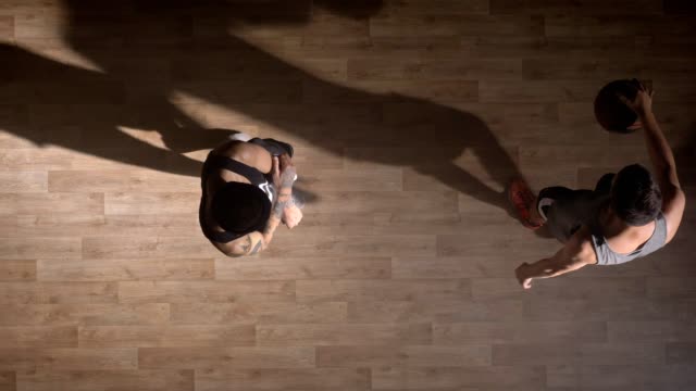 Topshot,-two-basketball-players-playing-one-on-one-on-court-indoors