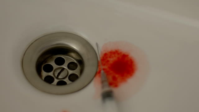 Blood-dropping-into-sink-with-empty-syringe,-drug-overdose,-call-emergency