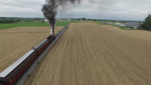 Dampfmaschine-Zug-schnaufend-entlang-Landschaft