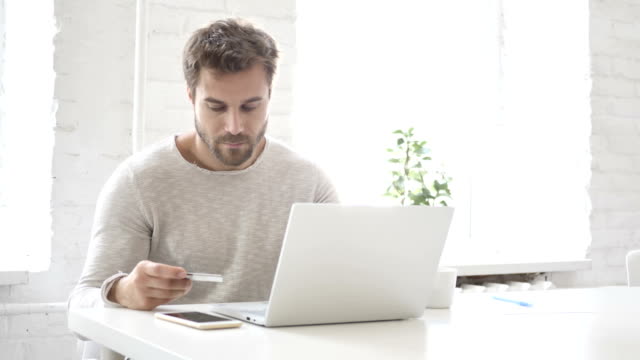 Pago-online-con-tarjeta-de-débito-por-el-hombre-en-portátil