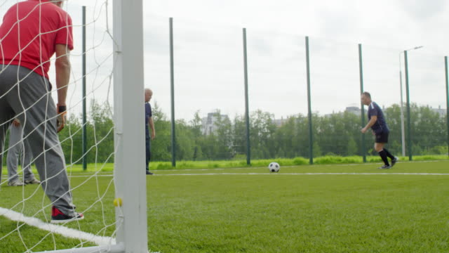 Hombres-jubilados-jugando-con-fútbol-al-aire-libre