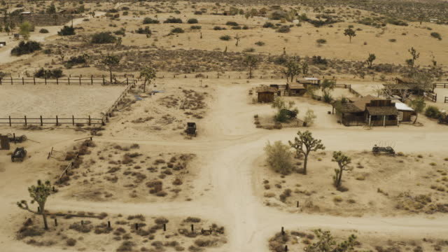 Flug-über-Bäume-und-Häuser-in-der-Wüste.