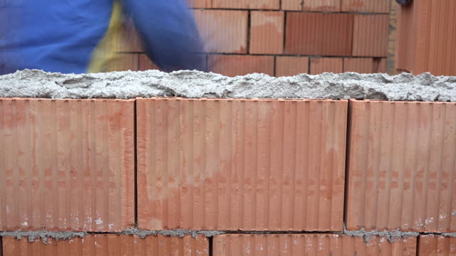 Worker-hands-apply-mortar,-arrange-bricks-on-masonry-wall,-build-house