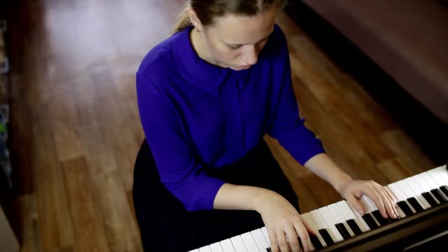 Chica-adolescente-juega-con-el-teclado-del-piano-digital.