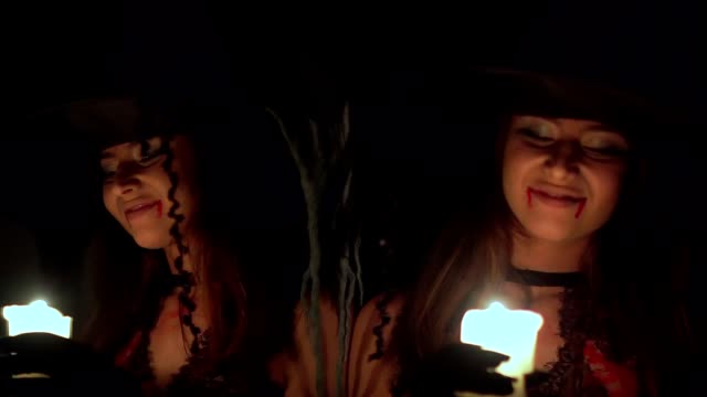 Halloween-Hexe-in-der-Dunkelheit-in-der-Nähe-des-Spiegels-mit-einer-Kerze.-Sie-sucht.