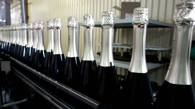 The-line-for-filling-and-sealing-the-conveyor-in-a-factory-of-champagne