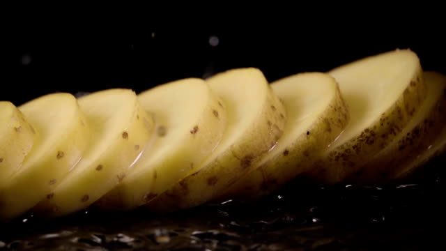 Falling-of-sliced-potatoes-into-the-wet-table.-Slow-motion-240-fps