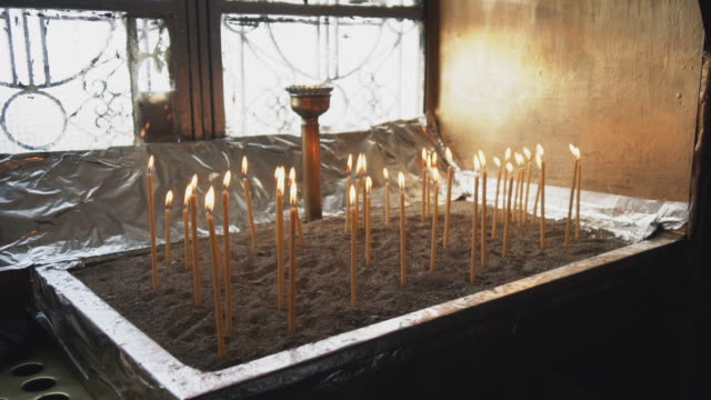 Viele-Kerzen-leuchten-auf-Tisch-in-der-Kirche.