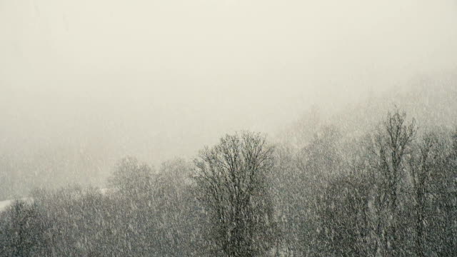 Strong-snowfall-in-the-mountains,-snow-falls-by-a-wall,-slow-motion