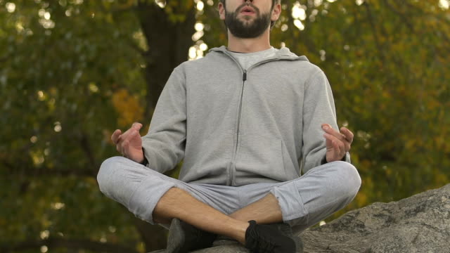 Sportlichen-Mann-sitzt-in-Lotus-positionieren-auf-Rock-oben,-Meditation-und-Entspannung,-hobby