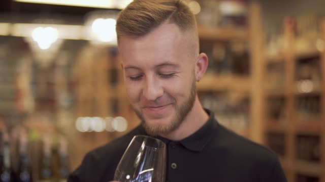 Portrait-of-attractive-man-drinking-red-wine.-Smiling-guy-raises-a-wine-glass,-winks-and-takes-a-sip.