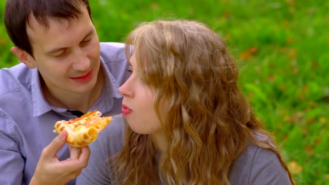 girl-biting-pizza-in-the-Park