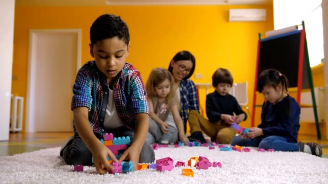 Positive-junge-Bau-mit-Spielzeug-Bausteine-erstellen