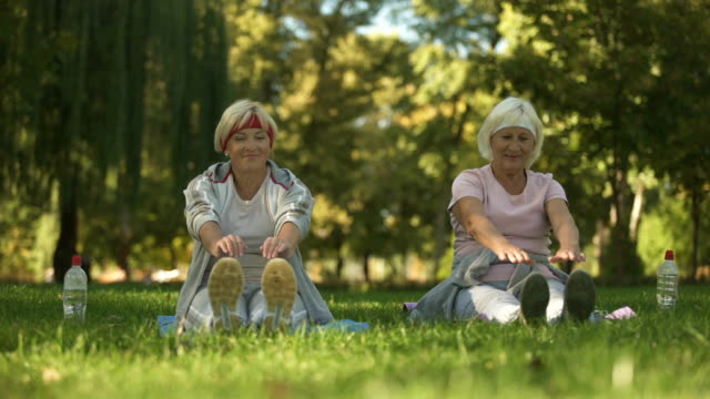 Mittleren-und-älteren-Alter-Frauen-trainieren-im-Park,-dehnen-ihren-Körper