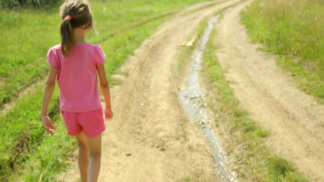 Kleines-Mädchen-zu-Fuß-entlang-der-Landstraße
