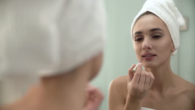 Lippen-Make-up.-Frau-mit-flüssiger-Lippenstift-im-Badezimmer