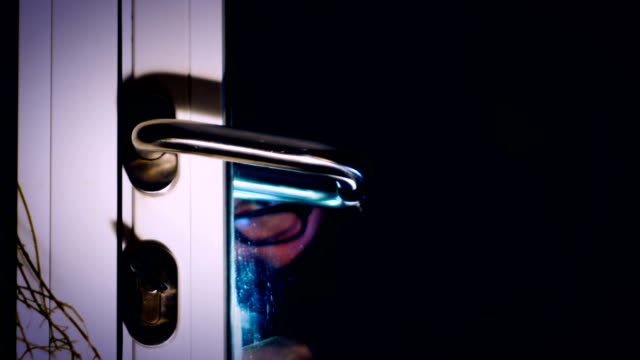burglar-enters-the-house,-breaking-through-the-glass-door-with-screwdriver