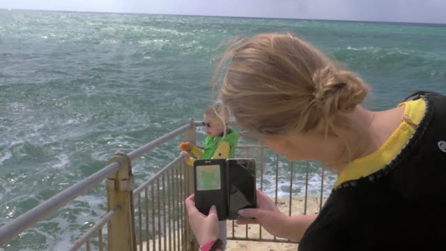 Mamá-tomando-la-foto-celular-del-niño-mirando-al-mar.-Rosh-Hanikra