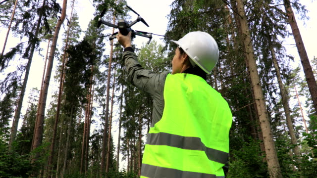 Mujer-trabajadora-con-Drone-Quadcopter-antes-de-despegar-en-el-bosque.-Inspección-de-bosques-de-vídeo