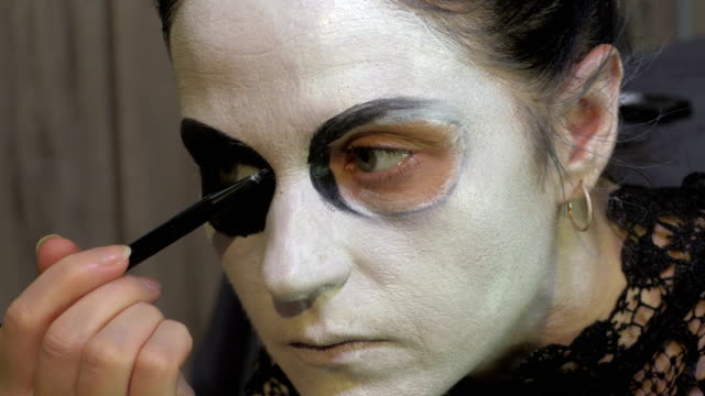 Mujer-con-lápiz-negro-rellenar-en-las-cuencas-oculares.-Concepto-de-ideas-de-maquillaje-de-Halloween