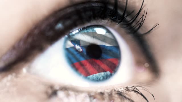 Frau-blaues-Auge-in-Nahaufnahme-mit-der-Flagge-von-Slowenien-in-Iris-mit-Windbewegung.-Videokonzept