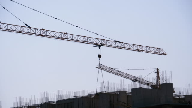 Tower-Crane-on-a-Construction-Site-eleva-una-carga-en-High-rise-Building